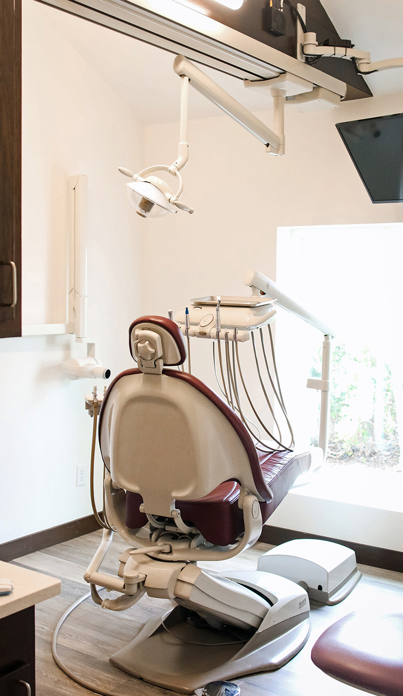The image shows a modern dental or medical office interior with a dental chair, equipment, and a clean, professional environment.